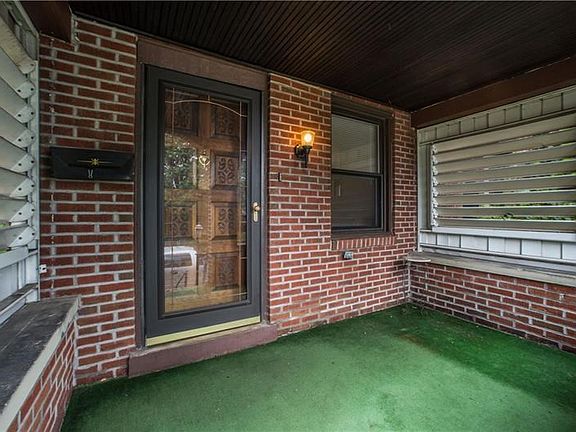 The repointed brick is in excellent shape creating a cozy front porch with privacy shutters on both sides.