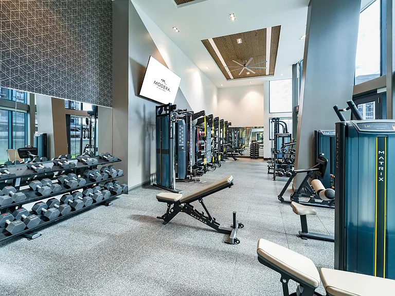 A modern fitness center at Modera McGavock, offering expansive training zones and advanced equipment.