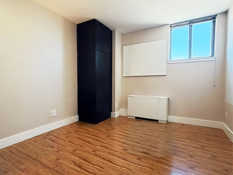 Bright second bedroom with hardwood floors and natural light_perfect for guests or a home office