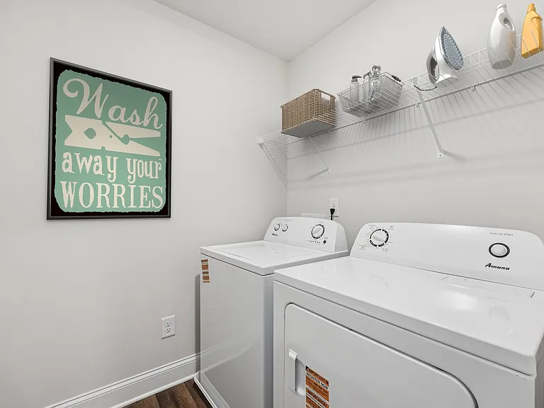 A spacious laundry room complete with full-size washer and dryer.
