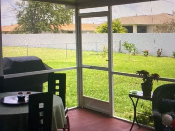 Covered and screened in patio with a view of the back yard