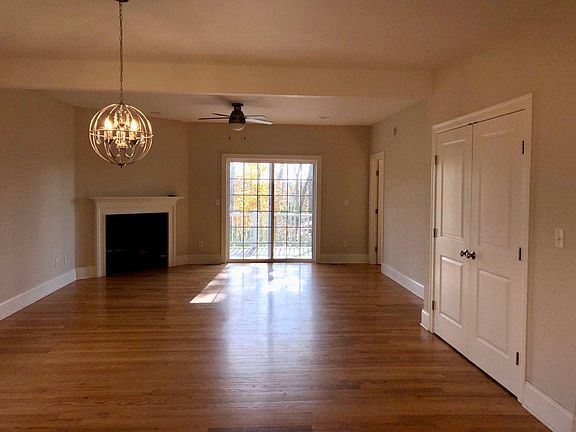 View from kitchen through dining room and living room. Storage closet on the right, has hookups for washing machine and dryer*. Fireplace. Walkout to deck. Door to main bedroom suite.
