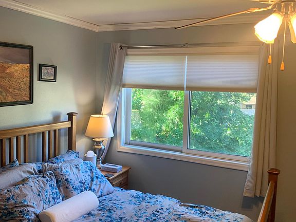 Primary bedroom overlooks open space with mature trees