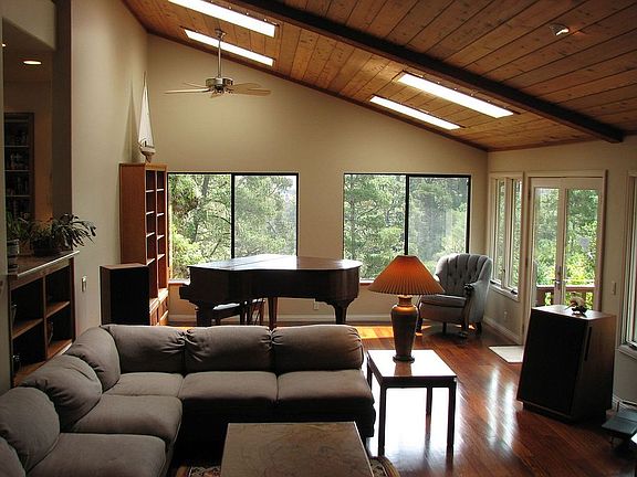 Living room: Hardwood floors, cedar ceilings, private views, fireplace.