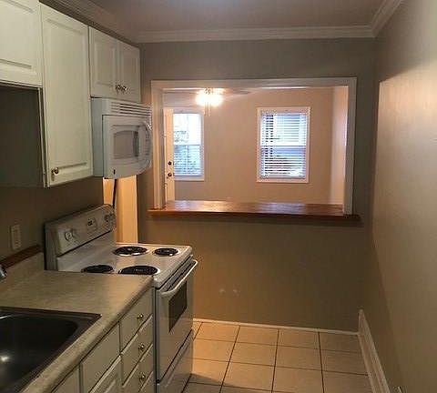Kitchen with electric stove, dish washer, microwave, refrigerator