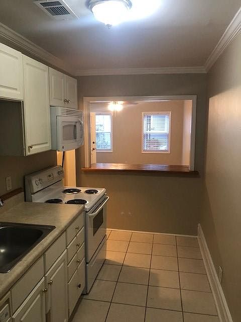 Kitchen with electric stove, dish washer, microwave, refrigerator