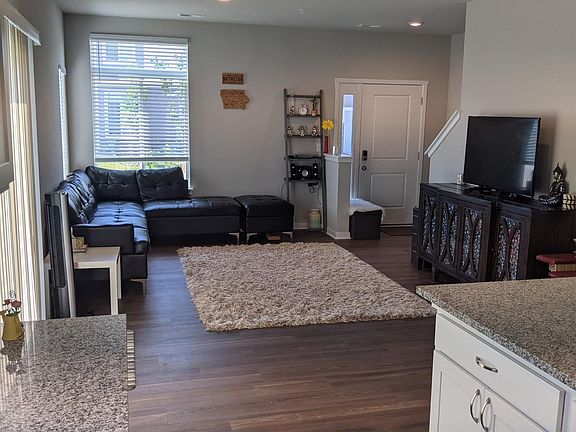 Well lit living room with high ceilings and walk out door small patio