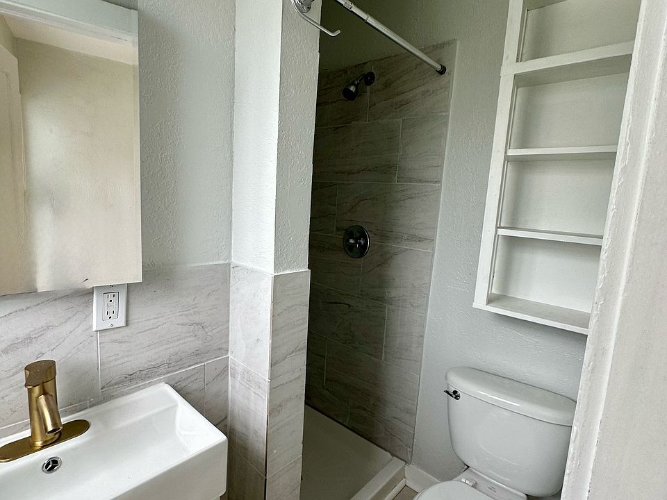 1929 bungalow bath mixes with new tiled shower and stylish porcelain sink. Left of sink there is a high window in bath keeping daytime bulb use to practically zero in entire apt.