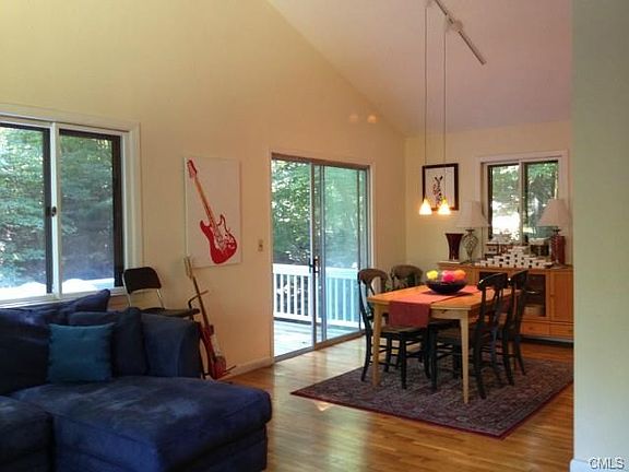 Dining Area Flows Into Living Area to Easily Accommodate Any Size Gathering. Sliders Lead to Large Wood Deck that Overlooks an Idyllic Seasonal Brook.