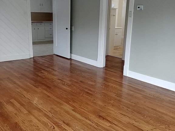 Right side of photo, Hallway leading to bathroom on right and bedroom to right of that. Built-in cabinets in hallway. Door way on left into kitchen, utility area.
