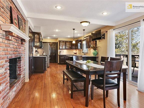 Open kitchen with beautiful fireplace, updates inc. painted cabinets, stainless appliances, granite, travertine backsplash.