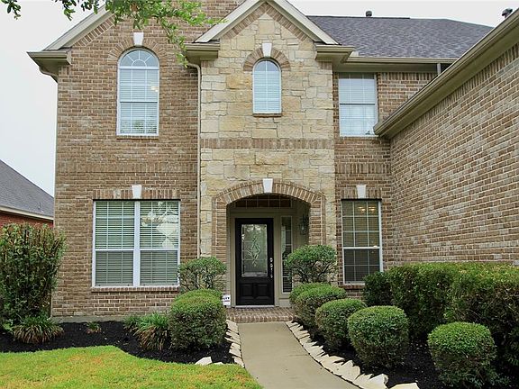 Manicured landscaping surrounds the walkway to the Covered Front Porch.