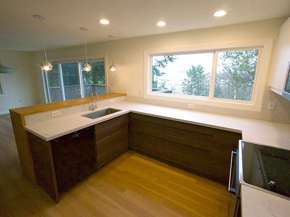 Chef's kitchen with breakfast bar, tons of counter space, great natural light, newer appliances including quiet dishwasher, and brand new cabinets and quartz counters. Full height cabinets (shown on plan) provide ample storage with a 36" wide fridge.