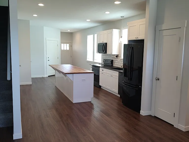 Living room facing kitchen and front door