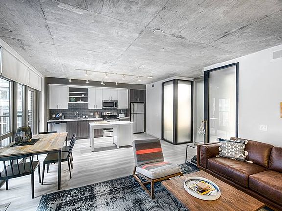 Open concept kitchen and living areas with hard surface flooring and floor to ceiling windows