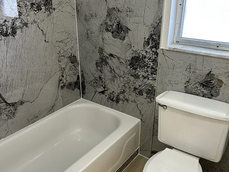 Updated bath with easy to care for tub surround.