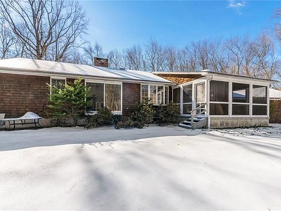 Back exterior picture of 65 Hunting Hill Rd in Woodbridge. Note the screen porch which is a perfect opportunity for finishing into year-round space and adding sq ft to this home.