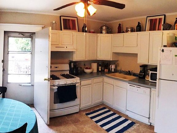 Kitchen is spacious and sunny with door that opens to private deck for expanded living space in warm months.