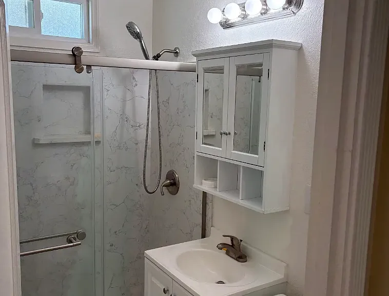 Upstairs bathroom w/ new vanity sink and mirror and shower