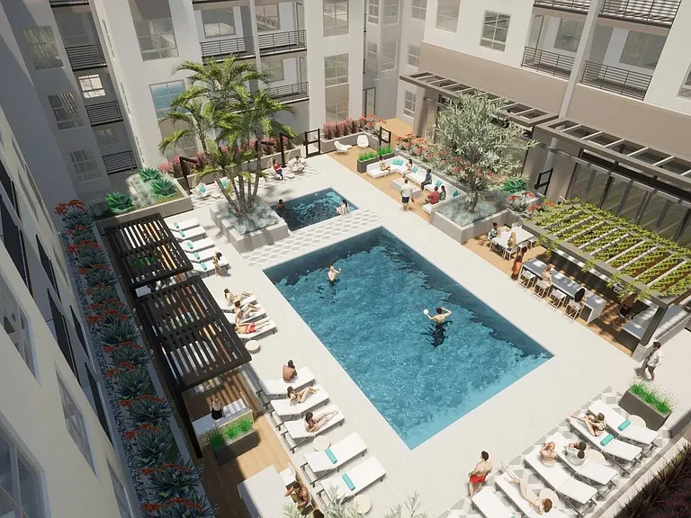A sun-filled courtyard with a central pool, shaded lounge areas, and spaces designed for gathering.
