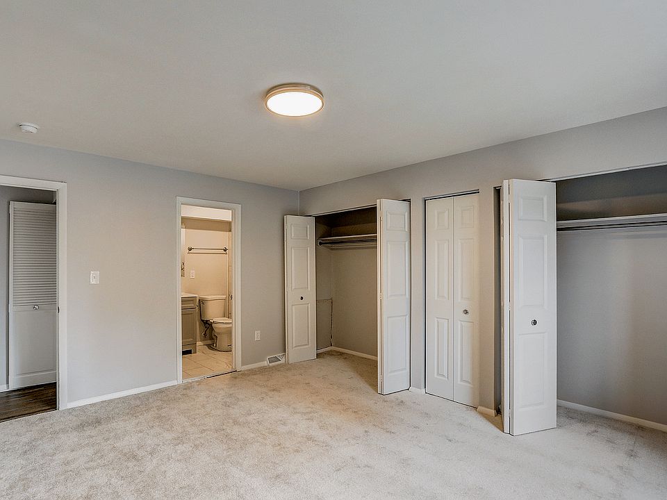 Explore this cozy bedroom featuring generous storage and a sleek bathroom entrance.