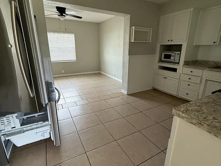Entering kitchen; the refrigerator is on the left side of the room