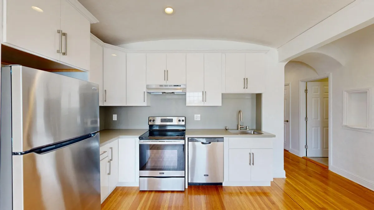 Kitchen with multiple cabinets, refrigerator, stove, range hood, and sink - 1290 20th Avenue