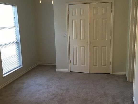 Front bedroom with neutral carpet and private bath