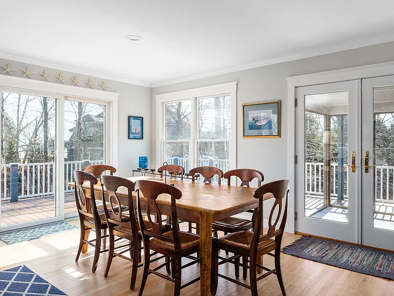 Dining area with doors to a large ocean-facing deck and cocktail porch.