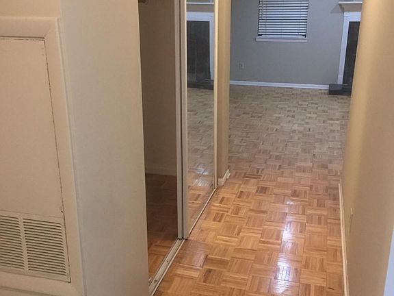 Entry way view of hallway to living room (kitchen is to the right and bedrooms/bathrooms and laundry are to the left)
