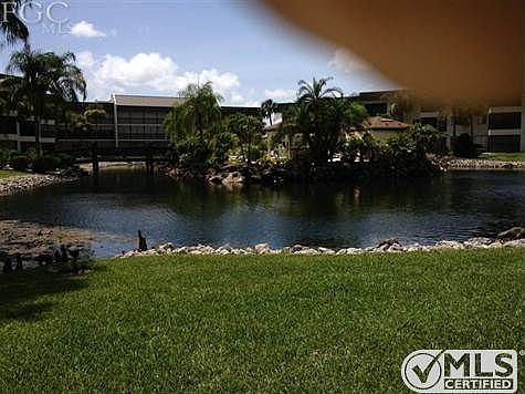 Lake between 3 bldgs. View from golf course.  Pool in middle of lake accessed by bridges  on both sides