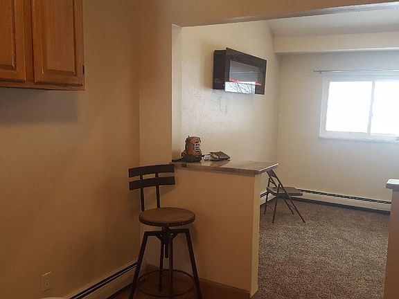 looking out from the kitchen into L.v. with breakfast bar and stools