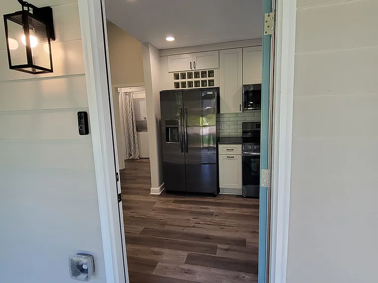 Entry to kitchen -- granite counterops, soft-close cabinets, and bottle storage above the refrigerator.