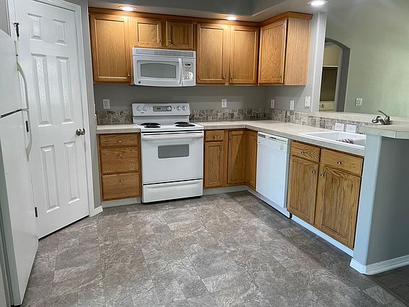 Kitchen w/regular-size fridge, stove, dishwasher, microwave, and garbage disposal.
