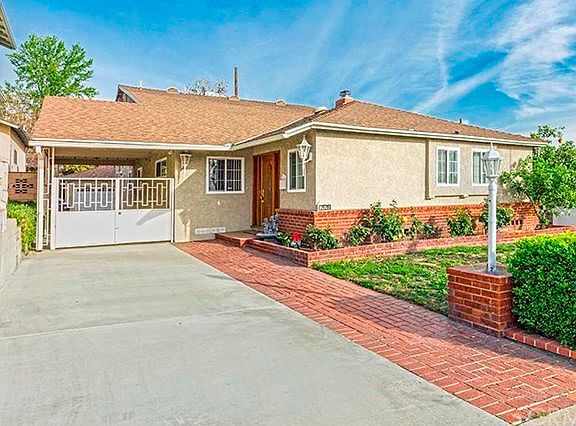 Front elevation of the home with long driveway, nice entry door, front landscaping.