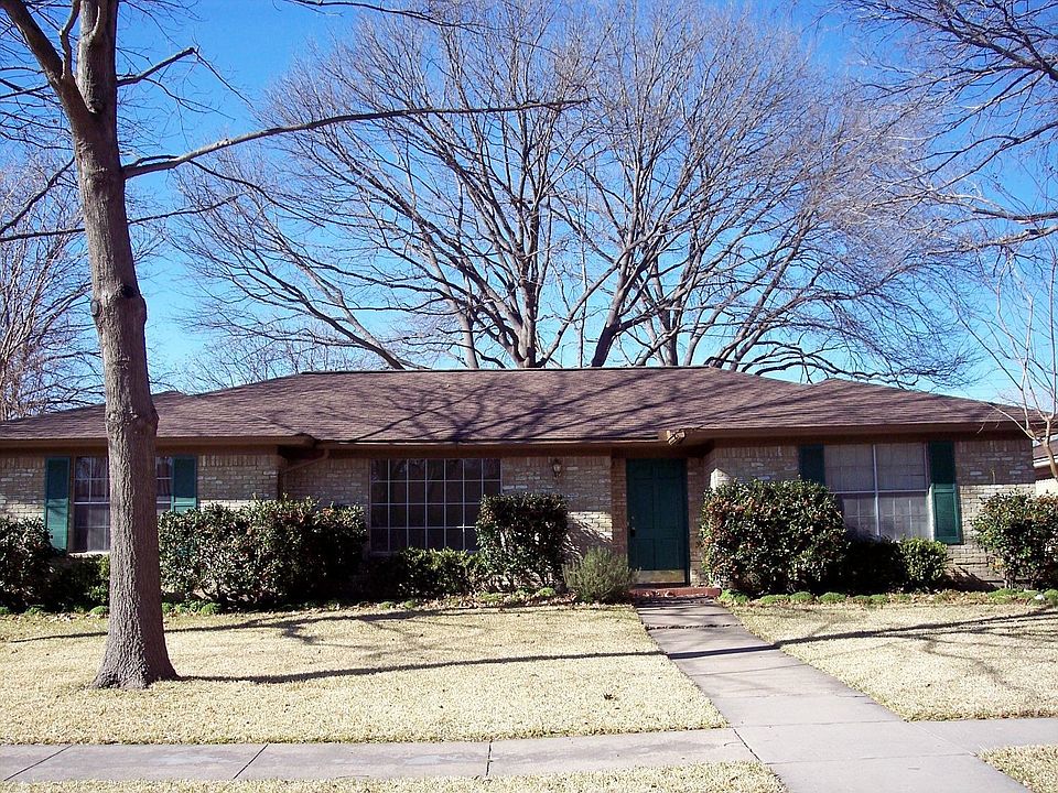Mature trees frame traditional home.