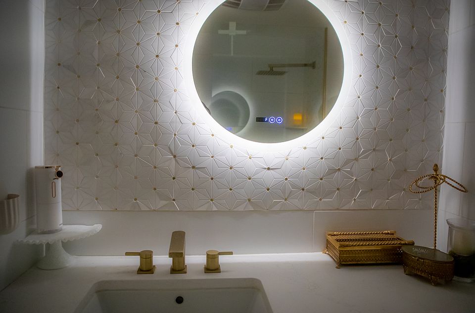 Updated second bathroom with gold mosaic accents, large tiles, and a spacious feel. Features a large vanity with gold fixtures, a relaxing rain shower head, a wide tub faucet, and an upgraded bidet toilet with automatic flush for added convenience.
