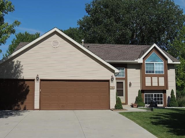 Three stall garage with newer concrete driveway and sidewalk