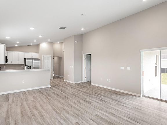 Enjoy a welcoming, open-concept living area with airy volume ceilings - Aurora by Highland Homes