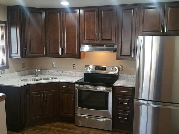 Cherry cabinetry and quartz counter-top. SS Fridge & Stove.