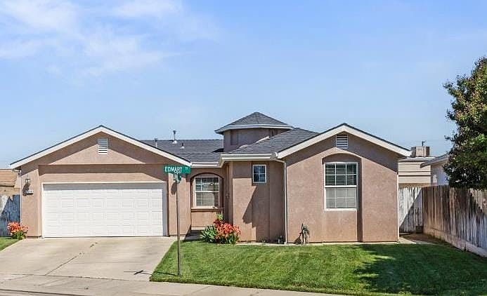 single story home with stucco siding, driveway, and a garage