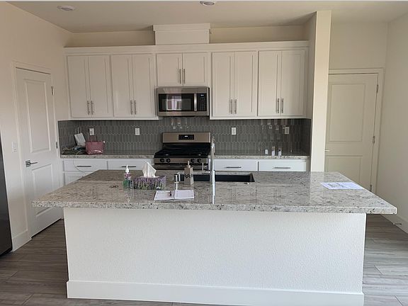This stunning, brand-new kitchen features sleek white cabinets that provide a clean, timeless aesthetic. The spacious layout is enhanced by gorgeous quartz countertops, offering not only a luxurious surface but also exceptional durability for daily use.