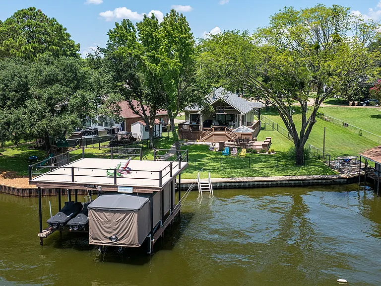 Backyard with covered patio and plenty of seating. With Access to lake and boat dock.