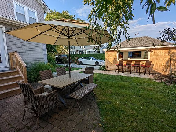 Private backyard surrounded by hedges and gardens.