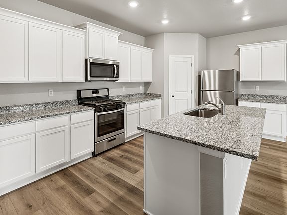 Chef-ready kitchen with a large island, sprawling countertops, and stainless appliances.