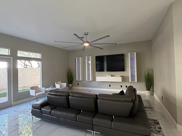 Alternate view of the furnished living room highlighting the oversized sectional and flexible seating layout.