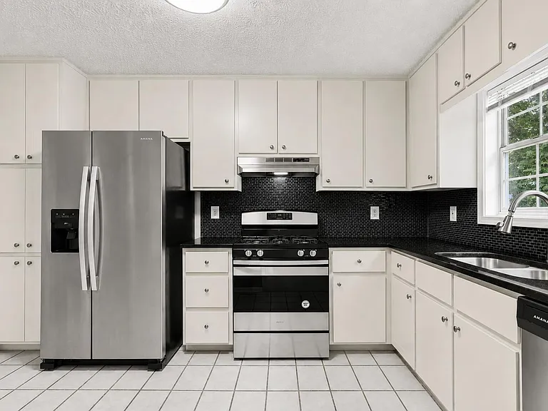 Fully stocked kitchen with cookware, dishes, and silverware.