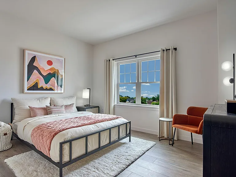 Experience tranquility in this elegantly designed bedroom, offering comfort and a stunning outdoor view.