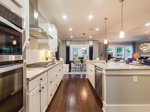 Beautiful Kitchen with over-sized kitchen island, white cabinets and gas Stainless Steel Appliances.