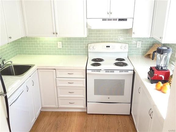 Fresh clean updated kitchen with new countertops, backsplash tiles, dishwasher and range.